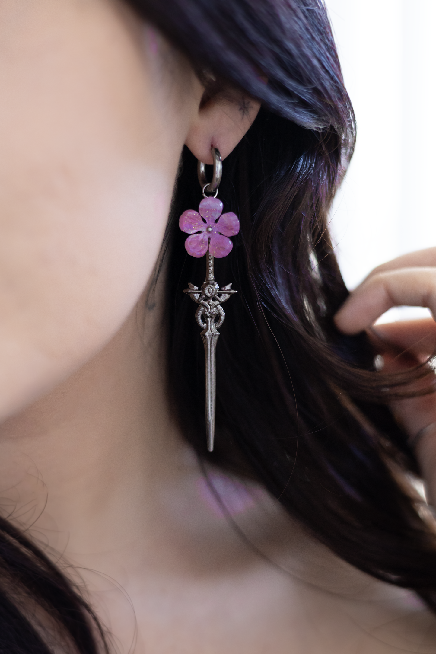 Close-up of a person wearing a floral earring with a blurred background