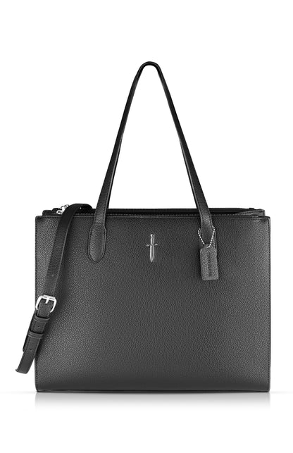 An image of a textured faux leather black tote bag with top handles and adjustable buckled shoulder strap, featuring a stylised emblem of a silver dagger in the top centre and includes a removable branded logo tag of the same fabric material.